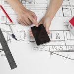human-hand-using-cellphone-blueprint-workplace